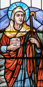 Delwedd o Sant Teilo yn gwydr lliw.